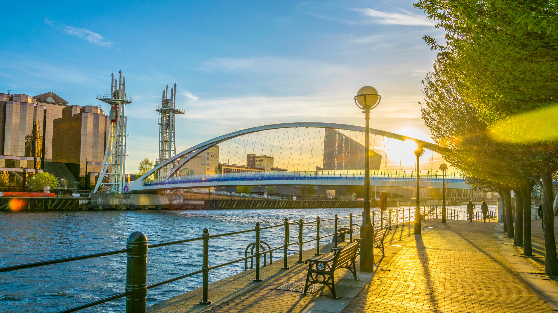 An image of Manchester at sunrise with blue skies and sunshine.